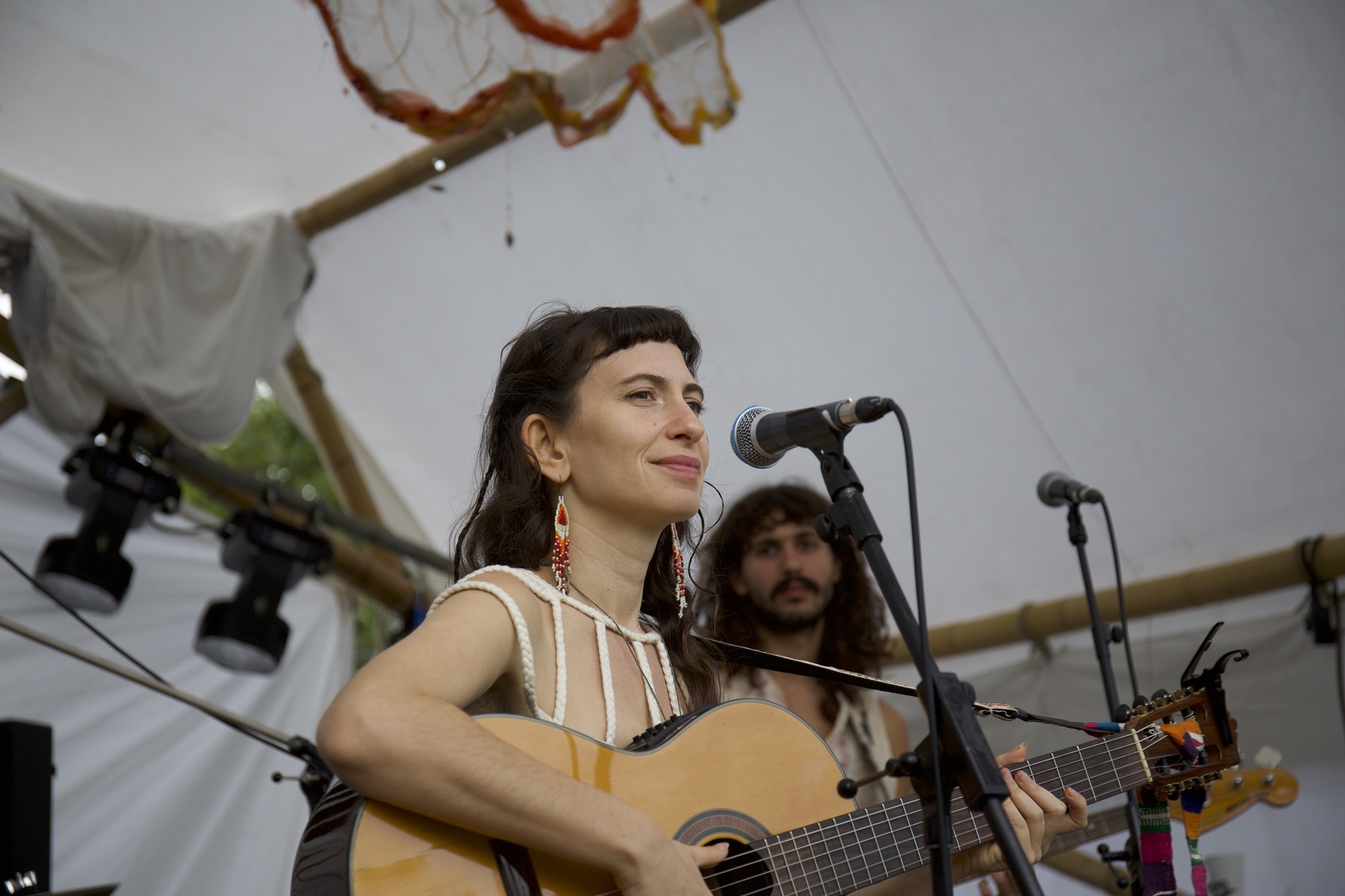 Yuli singing and playing guitar on stage at Ancient Trance festival