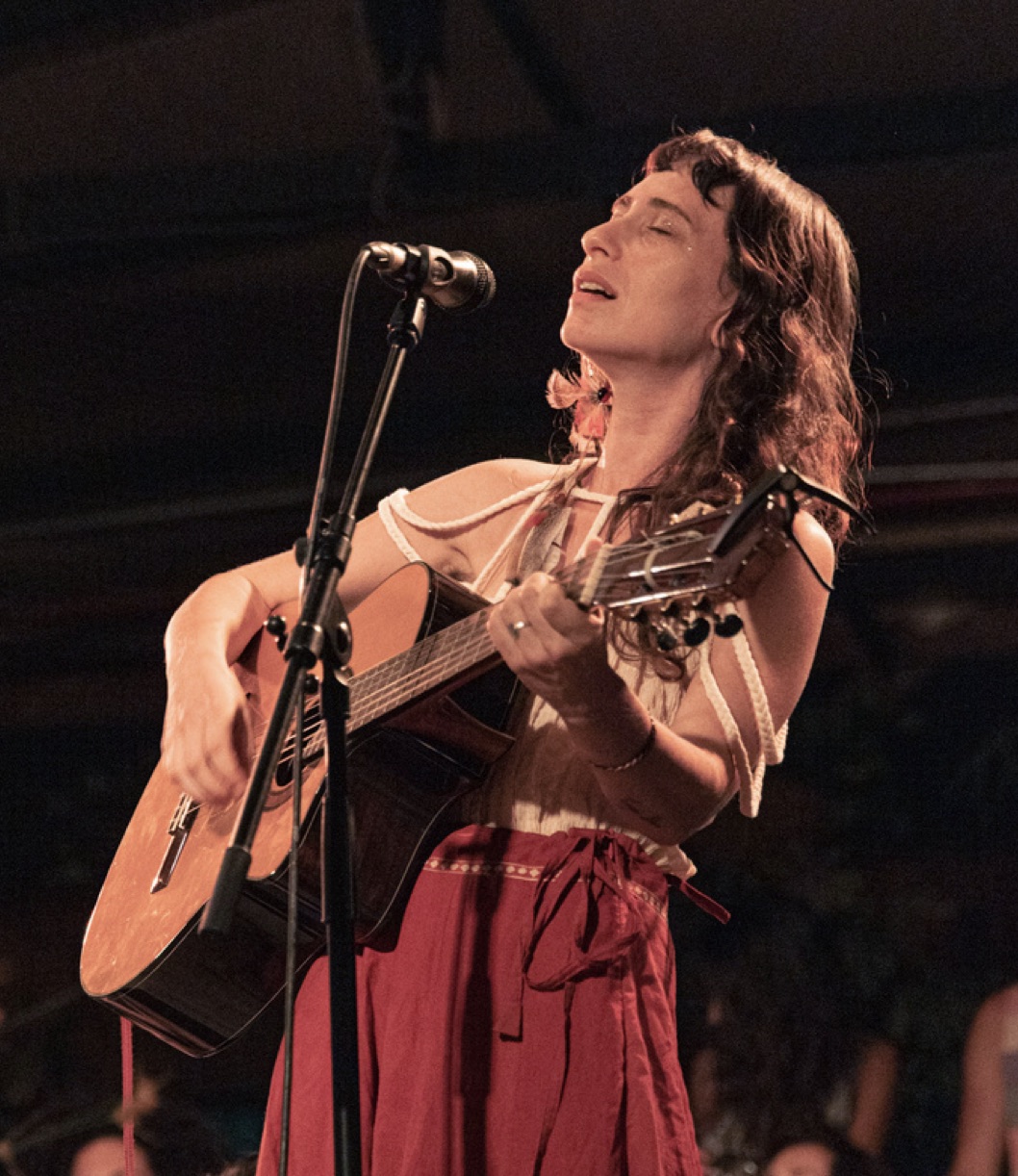 Yuli Shafriri singing with eyes closed, playing acoustic guitar